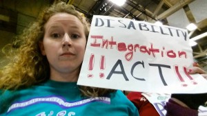 Stephanie Woodward holding a sign saying "Disability Integration Act" at a Ted Cruz rally in Rochester, New York