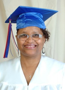 Headshot of Margo Hudson smiling wearing a white top and blue graduation cap