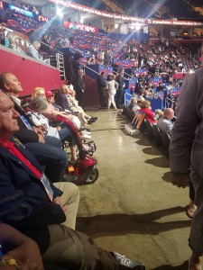 Image shows people in wheelchairs and with other disabilities seated at an ADA section at the RNC