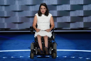 Anastasia Somoza seated in her wheelchair wearing a white lace dress on the DNC stage