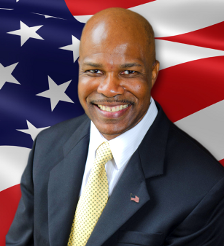 Headshot of Dwight Young with American flag in background
