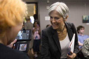 Jill Stein leaning over to shake hands with an attendee
