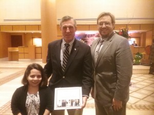 Delaware Governor Carney, RespectAbility's Phillip Pauli, and policy fellow Stephanie Farfan smiling as Governor Carney holds up an award