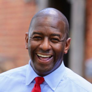 Andrew Gillum smiling in front of a blurred background