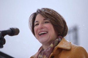 Amy Klobuchar speaks into a microphone amidst a blizzard