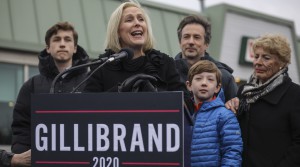 Gillibrand speaks at a campaign podium with her family surrounding her