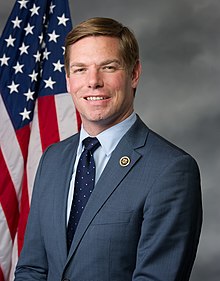 Swalwell smiles for the camera in front of the U.S. flag