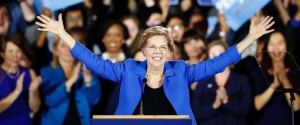 Warren waves with both arms to a crowd of supporters