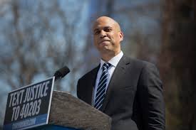 Booker stands behind a podium at a presidential campaign rally