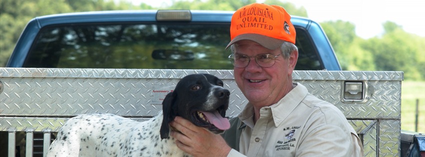 Foster Campbell poses for a picture with his dog while sitting in a pick-up truck