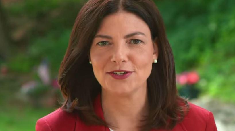 Kelly Ayotte headshot, outside, red suit