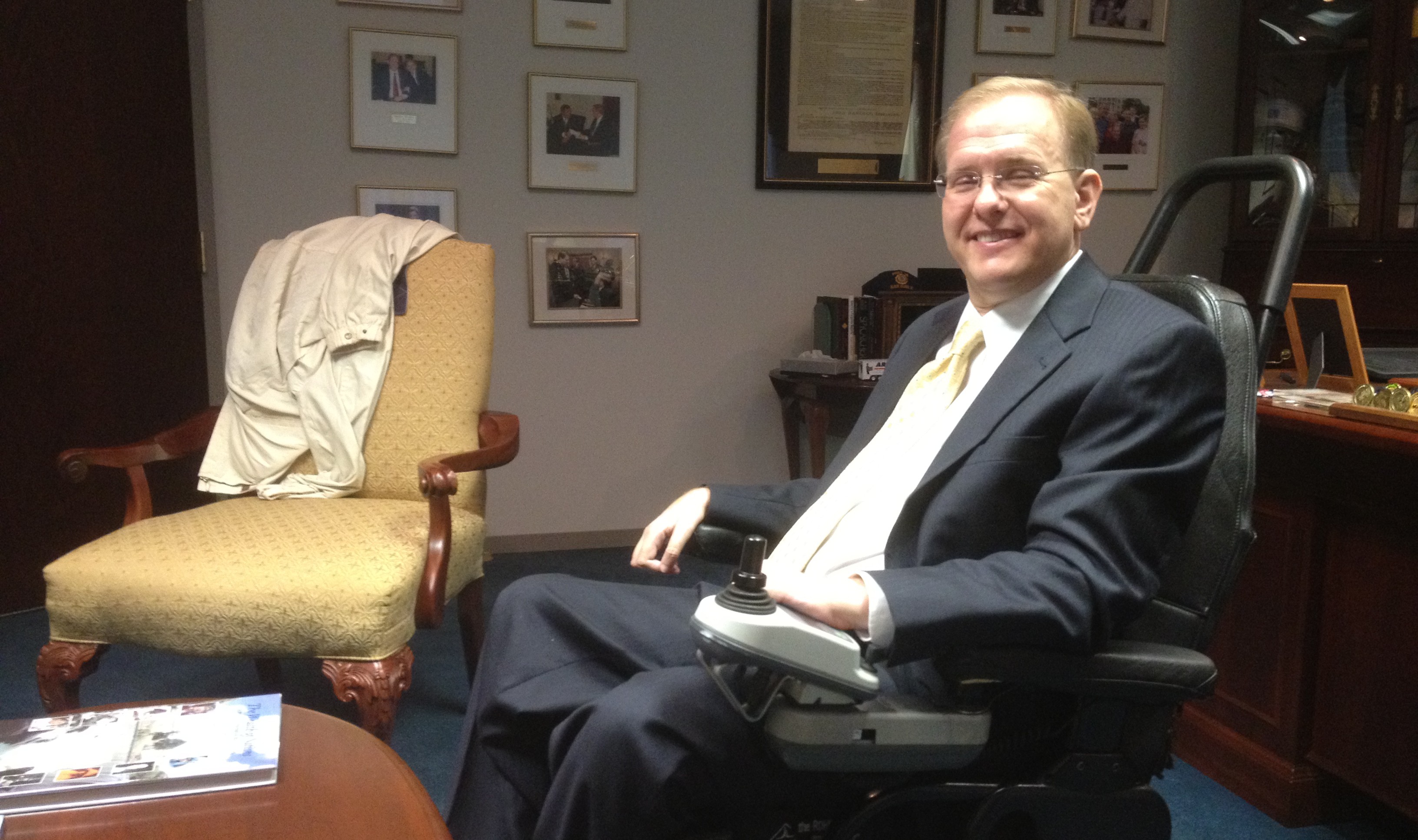 Jim Langevin seated in a power wheelchair in his office
