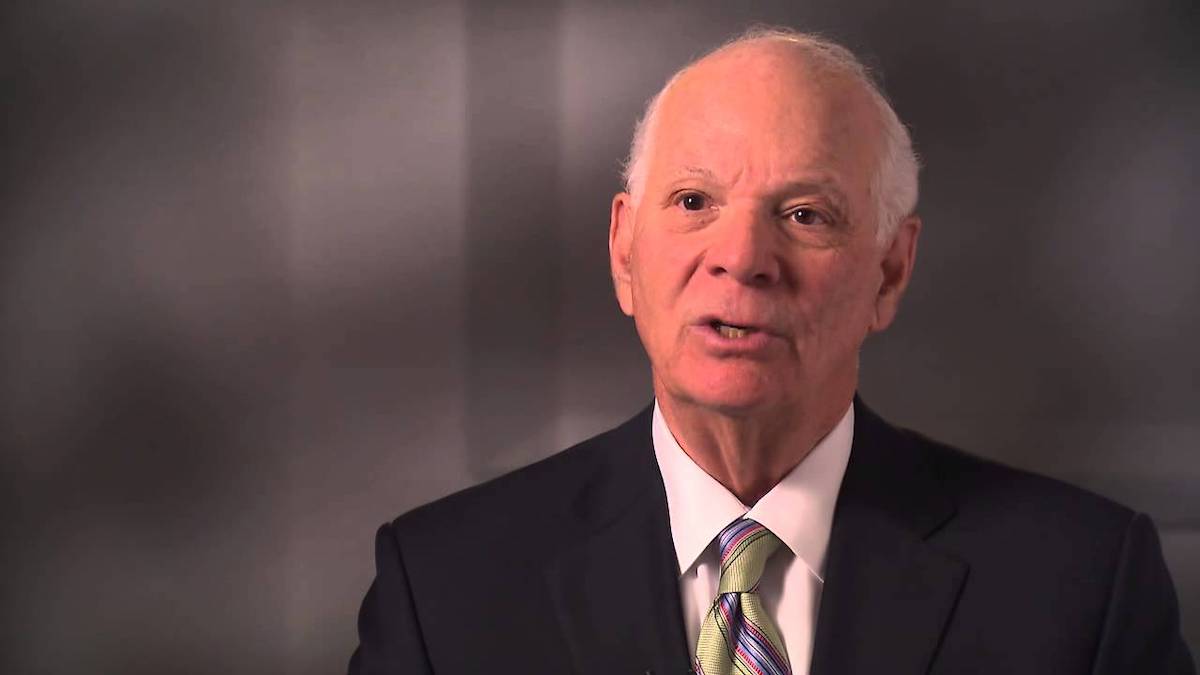 Ben Cardin speaking in front of a gray background