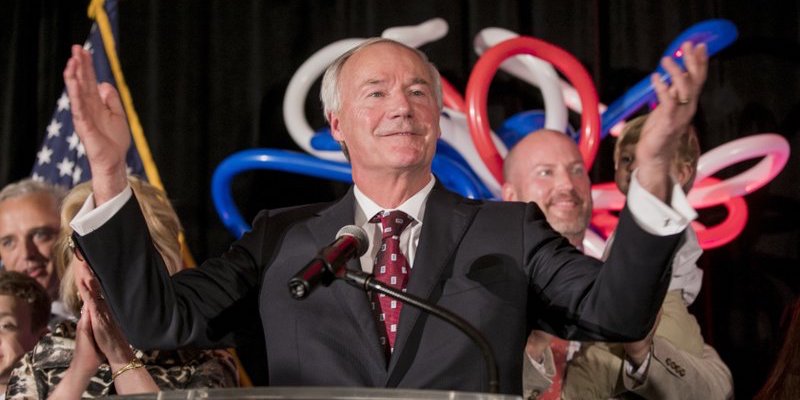 Asa Hutchinson speaks at his victory rally in front of supporters and balloons