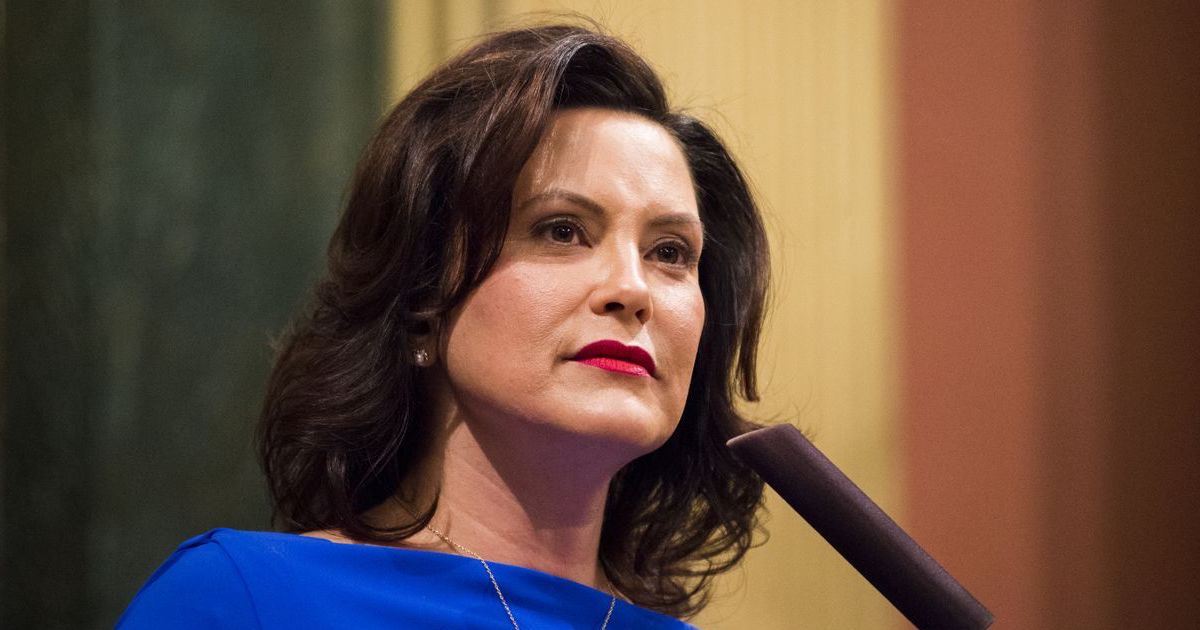 Gretchen Whitmer standing behind a microphone