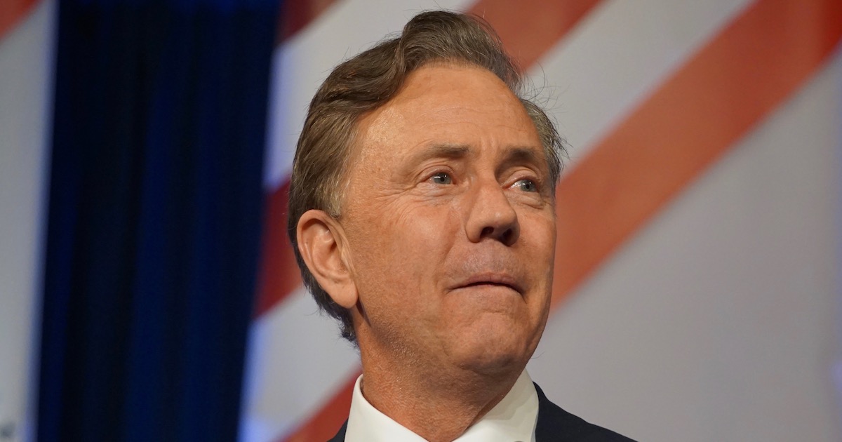 Ned Lamont onstage in front of an American flag