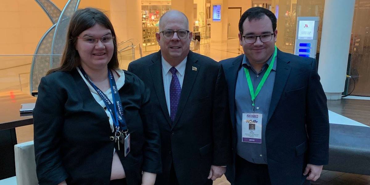 L-R: Heidi Wangelin, Maryland Governor Larry Hogan, and Eric Ascher smile together in the Marriot Marquis Lobby.