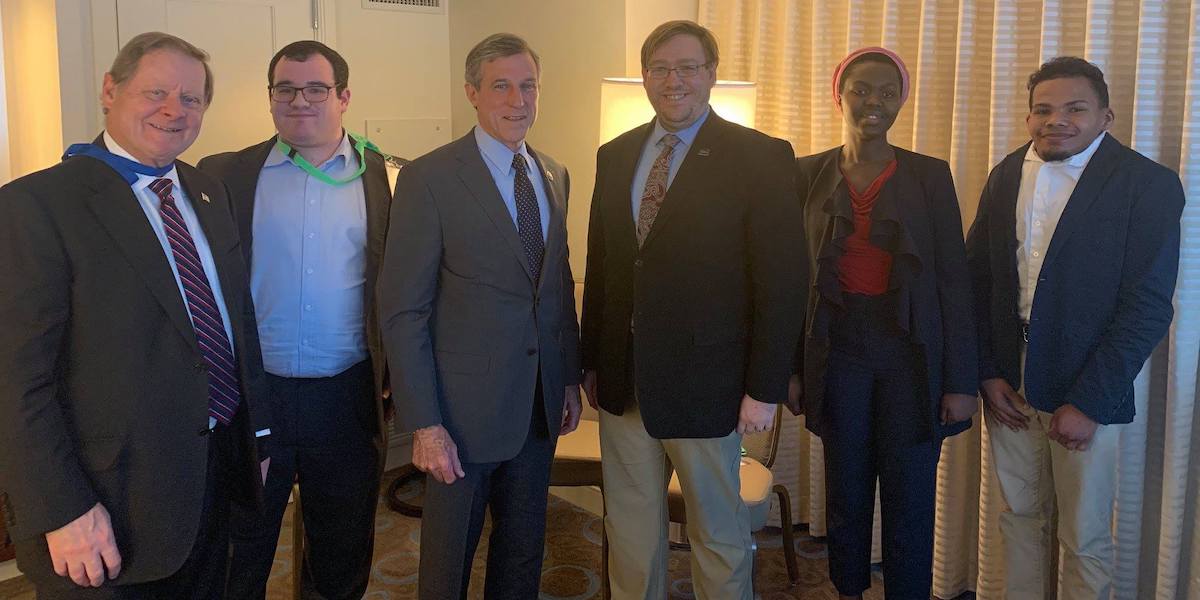 Delaware Governor John Carney with RespectAbility staff and Fellows, smiling