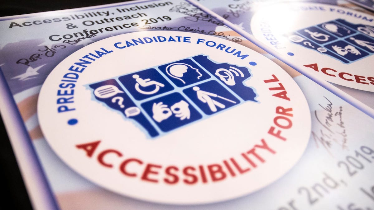 A poster with the logo for the Accessibility For All Presidential Candidate Forum signed by several candidates.
