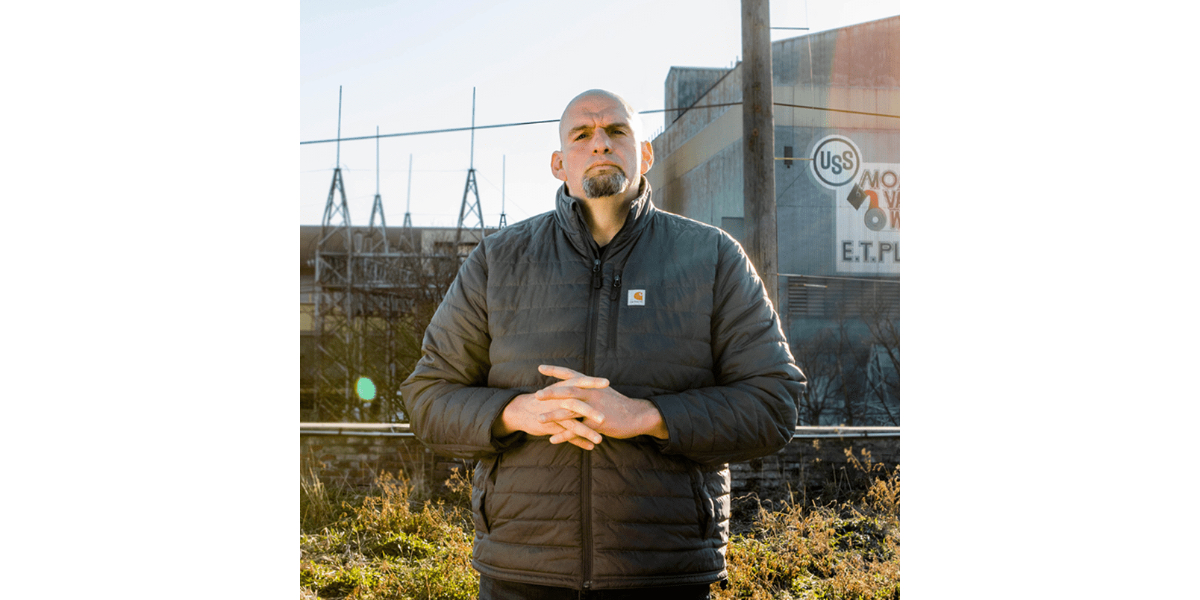 John Fetterman standing in front of a factory